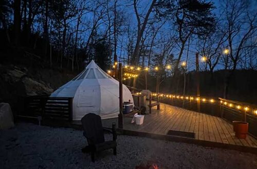 Campsite at night with fire and string lights